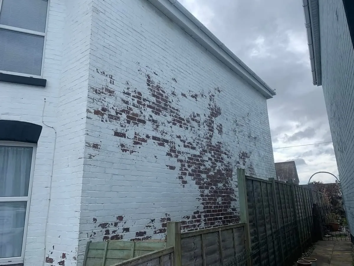 Peeling paint on a brick wall before redecoration in Torquay